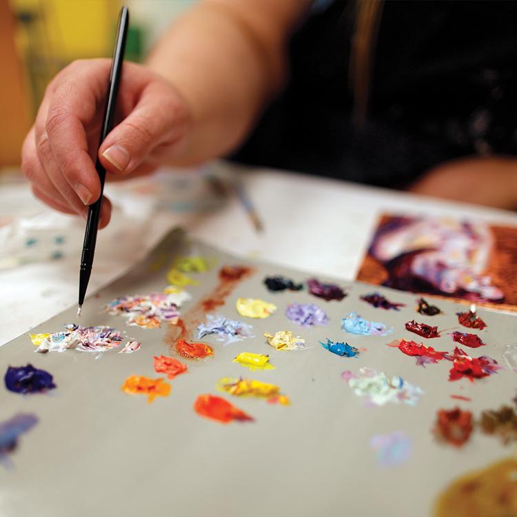 A close up view of a paint palette and brush